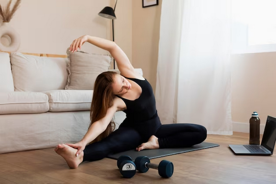 Woman Practicing Yoga in Front of Laptop with Dumbbells Nearby