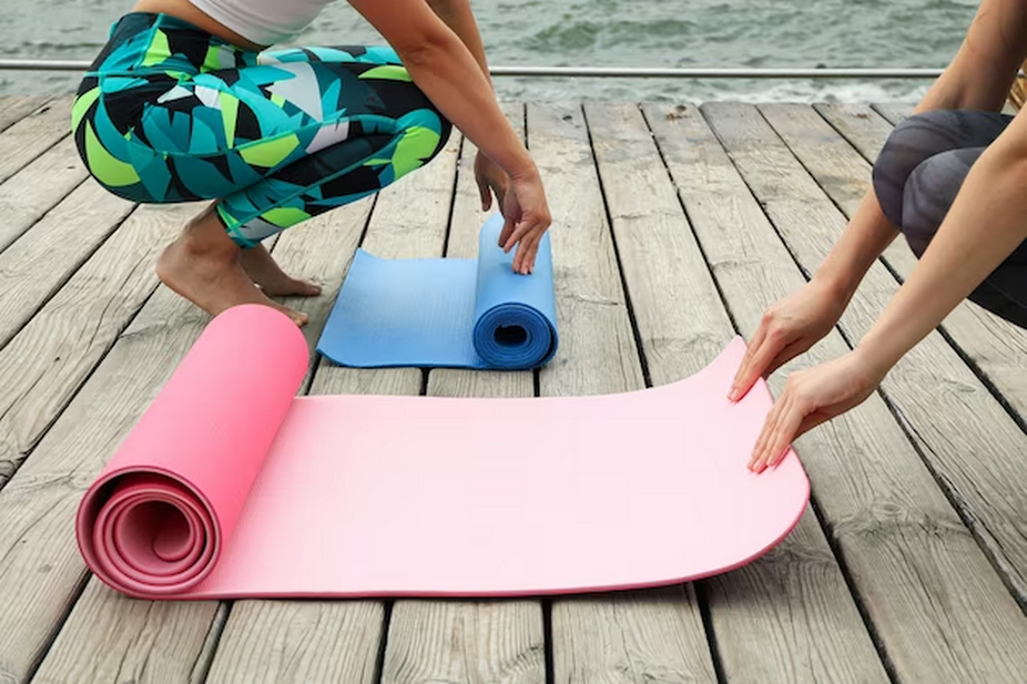 Two people setting up their yoga mats.