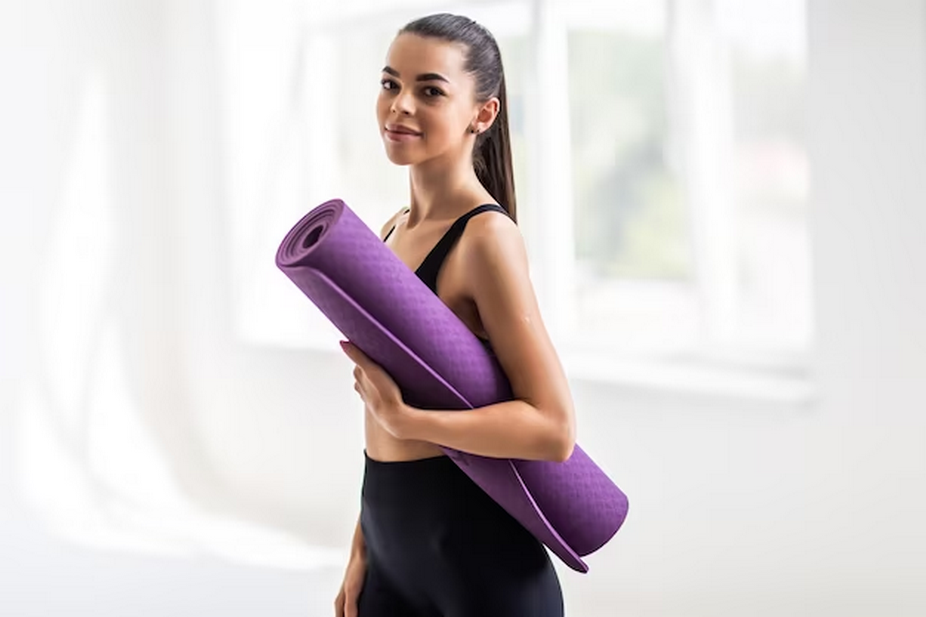 Female holding a yoga mat